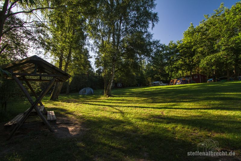 Foto Campingplatz: eine Wiese mit einer überdachten Sitzgruppe