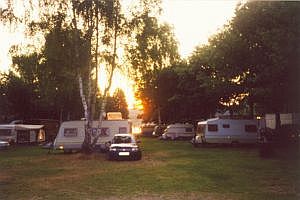 Foto: Campingplatz mit Wohnmobilen bei Sonnenuntergang